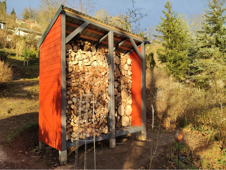 Roter Holzschuppen voller Brennholz