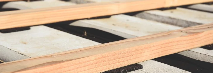 Holzbalken auf Betonfundament