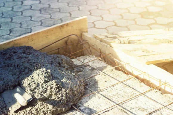 Frischer Beton und eine Kelle in einem Fundament
