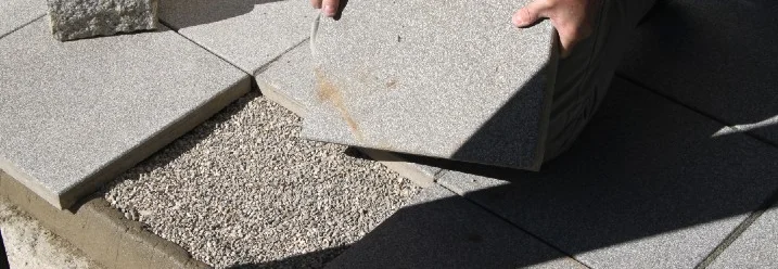 Person verlegt Terrassenplatten