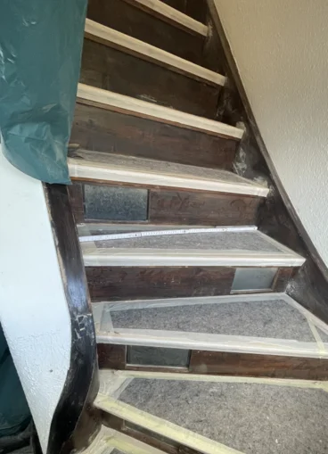 Abgeklebte Holztreppe mit Zollstock