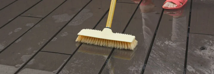 Person schrubbt Holzboden mit Schrubber