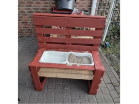 Roter Sandkasten aus Palettenholz