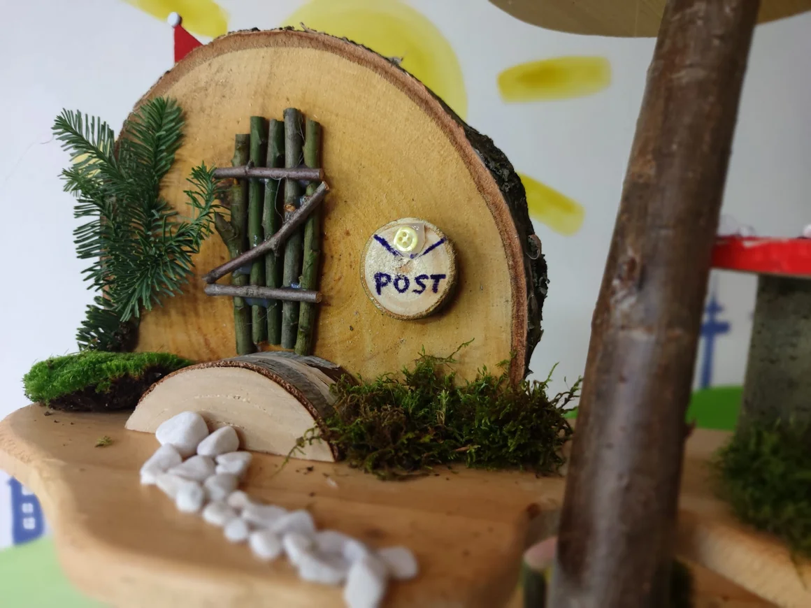 Ein gebasteltes Miniaturhaus aus Holz mit einem „Post“-Schild.