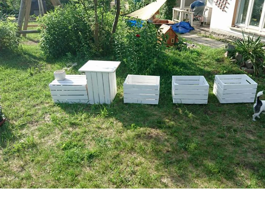 Fünf weiße Holzkisten im Garten