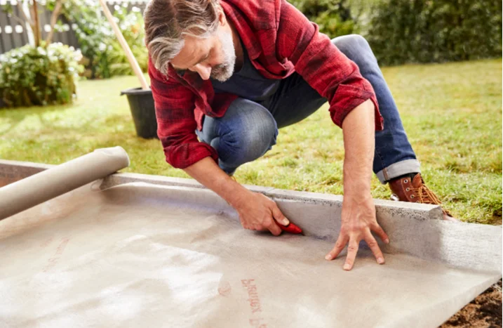 Person schneidet mit Cuttermesser Plane zu