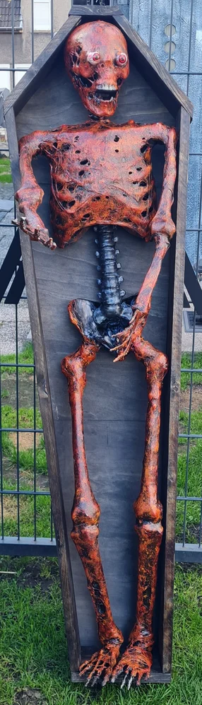 Horror-Skelett als Halloween-Dekoration in einem Holzsarg