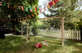 Selbstgebautes Fußballtor mit Werkzeug und Länderflaggen im Garten.