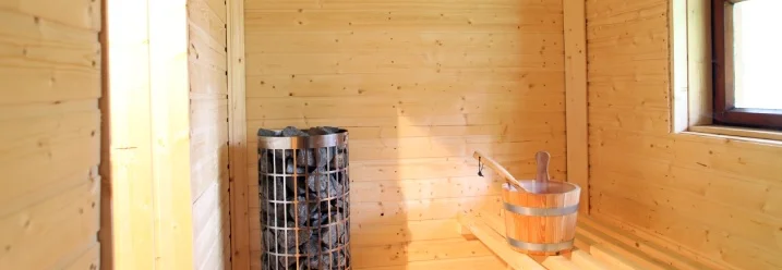 Leere Sauna mit Saunaofen und Holzeimer