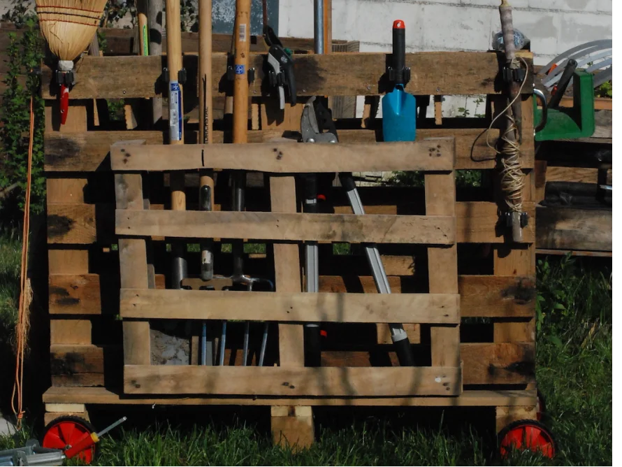 Gartenwerkzeug an einer Palette aufbewahrt