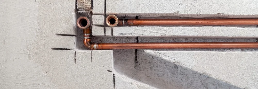 Kupferrohre in Betonwand
