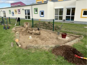 Gartenarbeit mit Schaufel und Baumstämmen