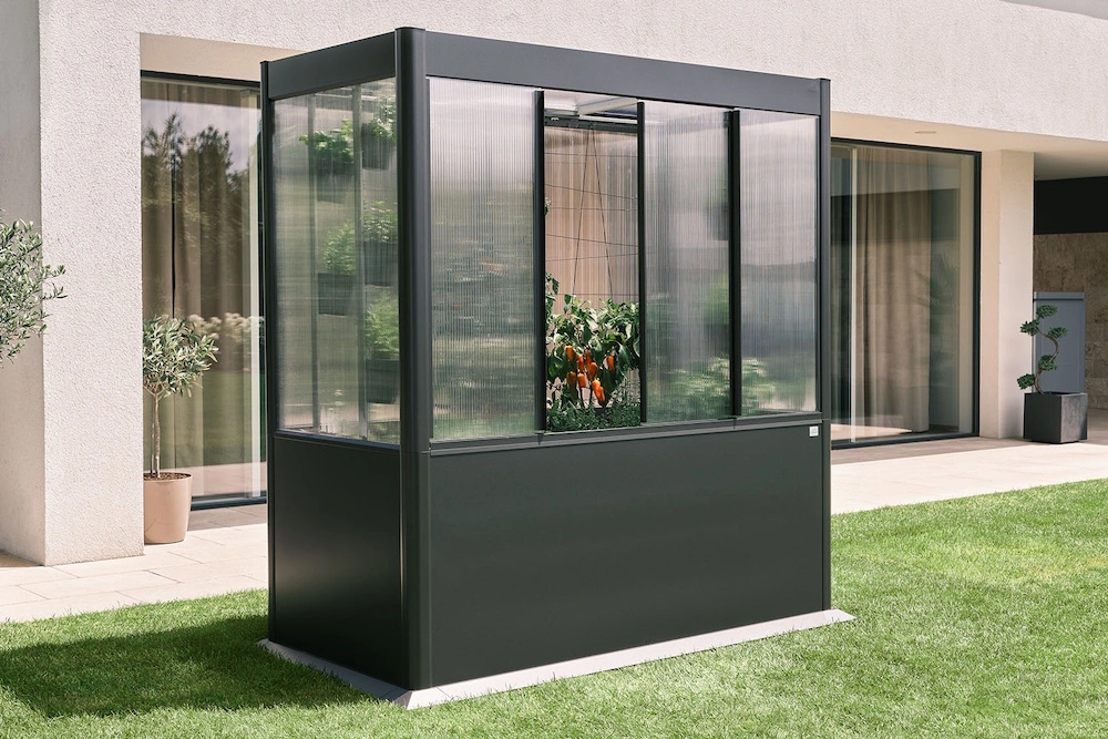 Ein Biohort Design-Gewächshaus steht in einem Garten