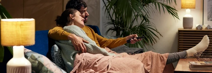Zwei Personen kuscheln auf einem Sofa