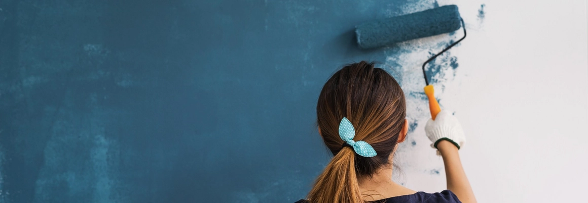 Person streicht Wand blau