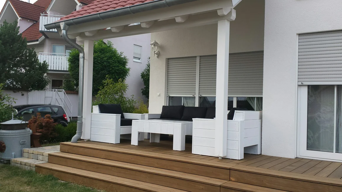 Weiße Gartenmöbel auf Holzterrasse