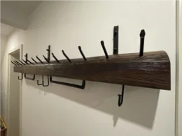 Garderobe aus dunklem Holz mit schwarzen Haken
