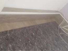 Holzsockel an Wand und Teppich