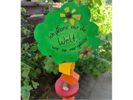 Ein grünes Schild in Baumform mit der Aufschrift 'Ich pflanz' mir die Welt...'