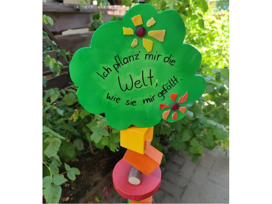 Ein grünes Schild in Baumform mit der Aufschrift 'Ich pflanz' mir die Welt...'