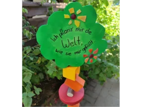 Ein grünes Schild in Baumform mit der Aufschrift 'Ich pflanz' mir die Welt...'