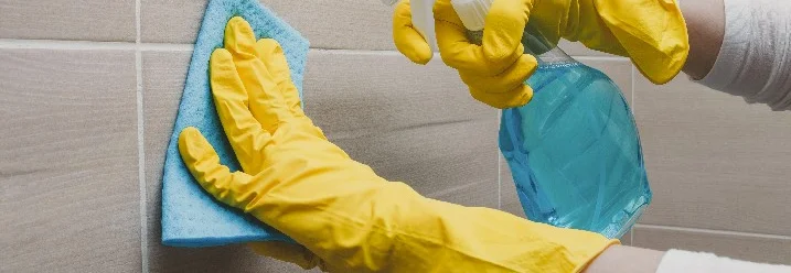 Person reinigt Fliesen mit Lappen