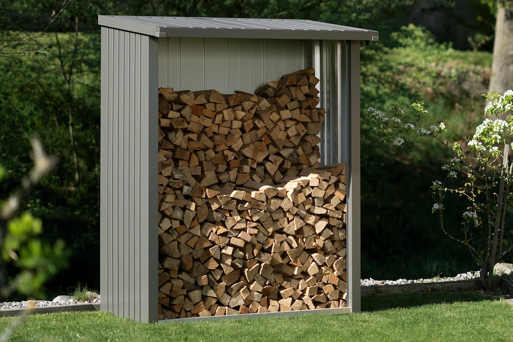 Ein Biohort-Brennholzlager voller Holzscheite steht in einem Garten