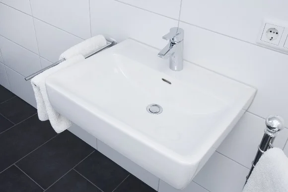 Weißes Waschbecken mit Handtuchhalter