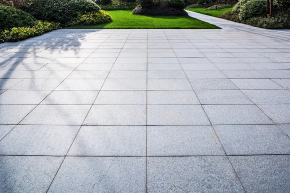 Gepflasterte Terrasse mit Rasenfläche