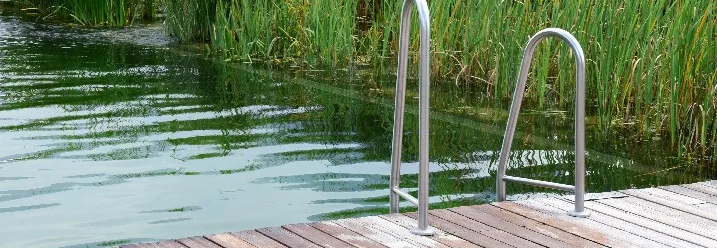 Schwimmteich mit Leiter und hölzernem Deck