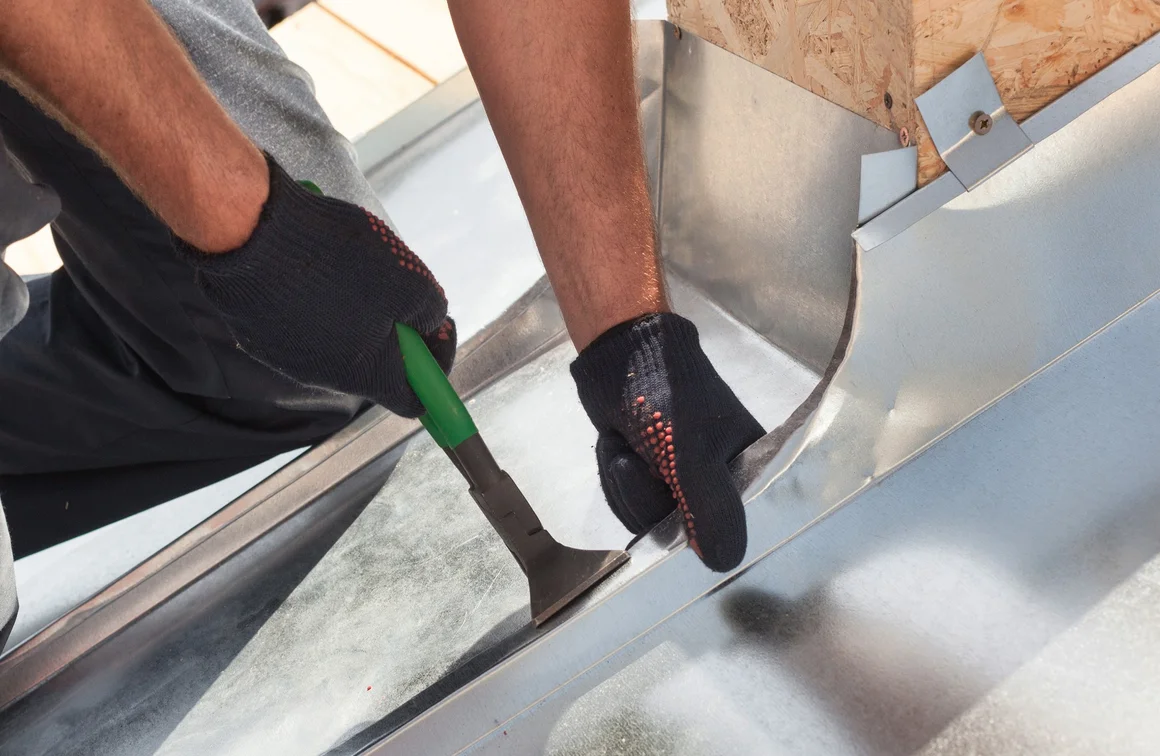Handwerker biegt Blech mit Zange