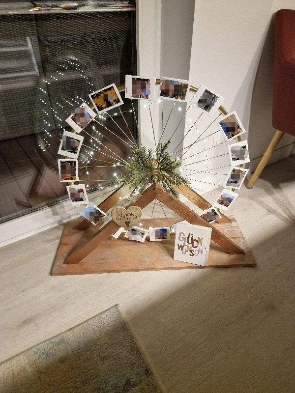 Selbstgebautes Riesenrad als Fotorahmen mit Lichterkette und Fotos.