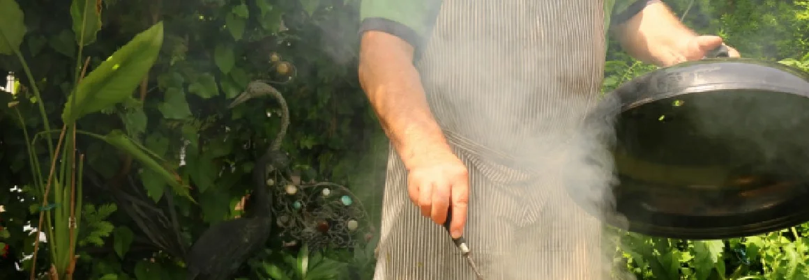 Person grillt mit Grillzange