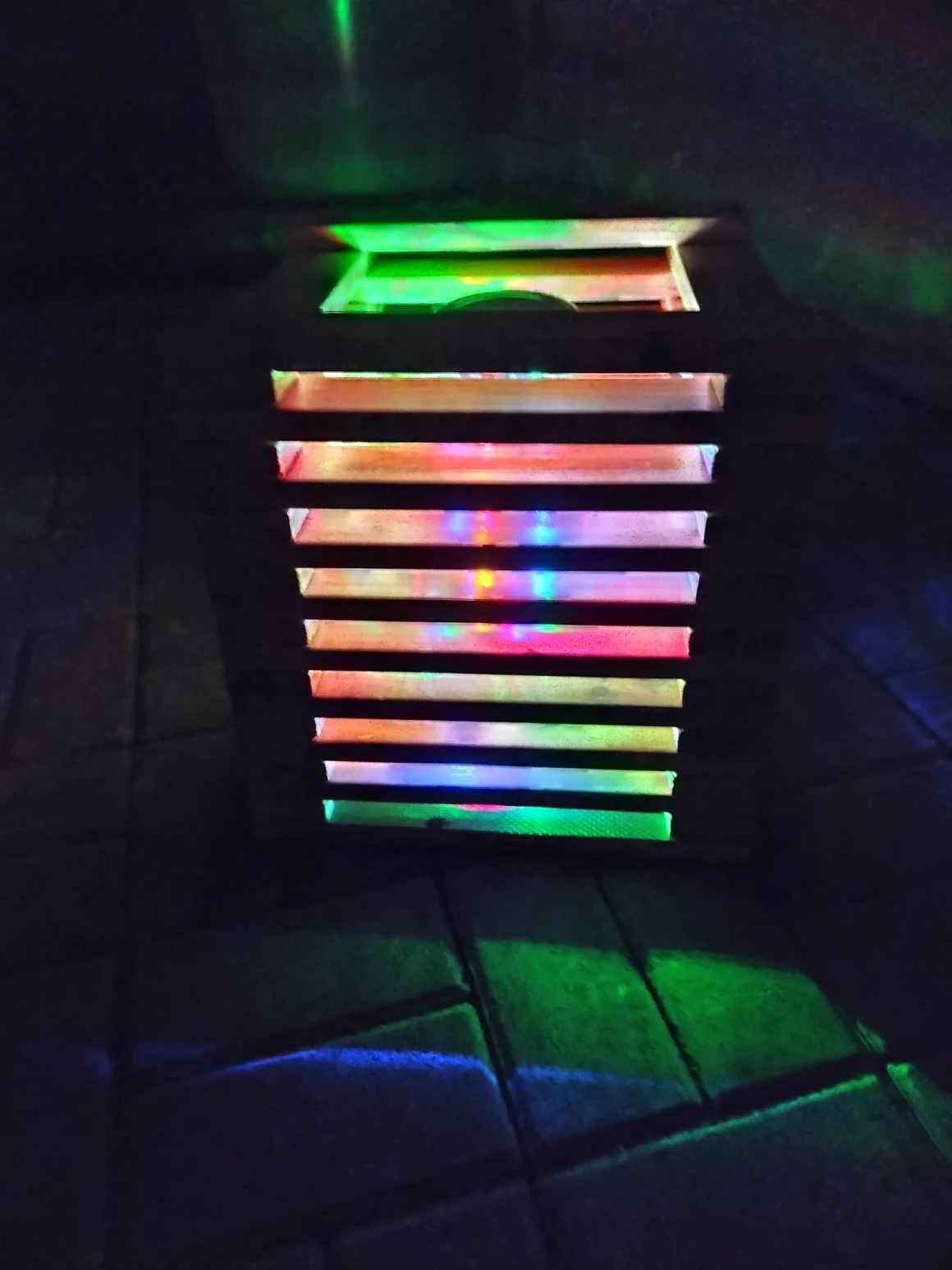 Buntes Licht scheint durch die Schlitze eines Kastens.