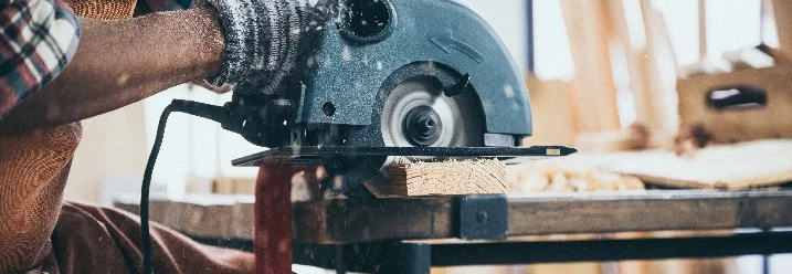 Person sägt Holz mit Handkreissäge