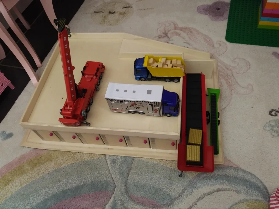Spielzeuglastwagen und -kran auf einem Tisch