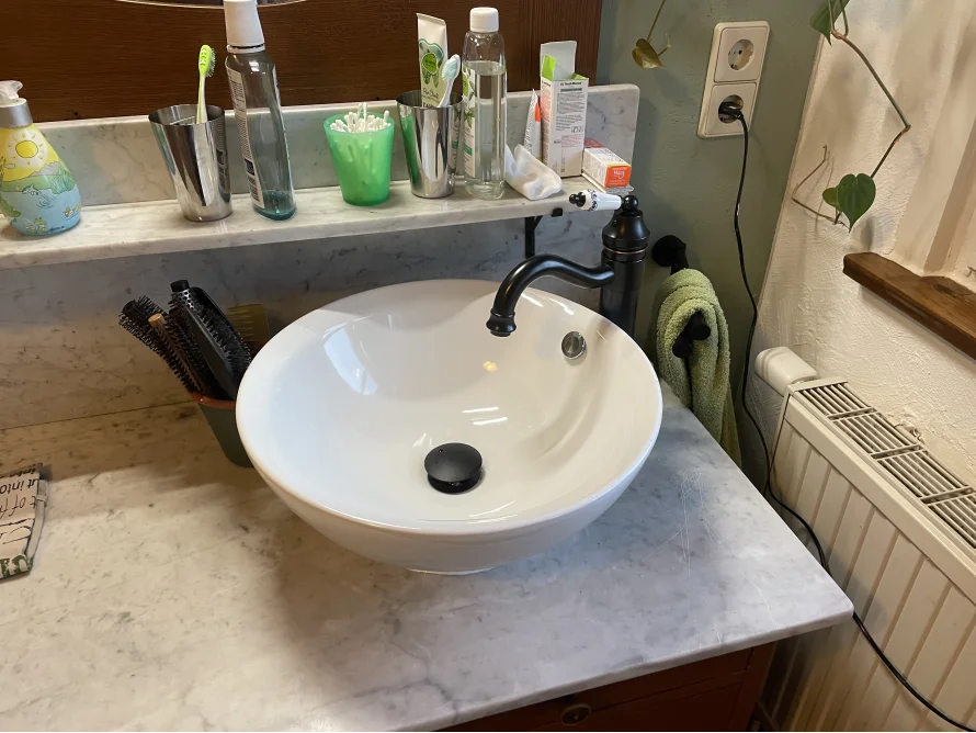 Waschbecken mit Hygieneartikeln und Handtuch