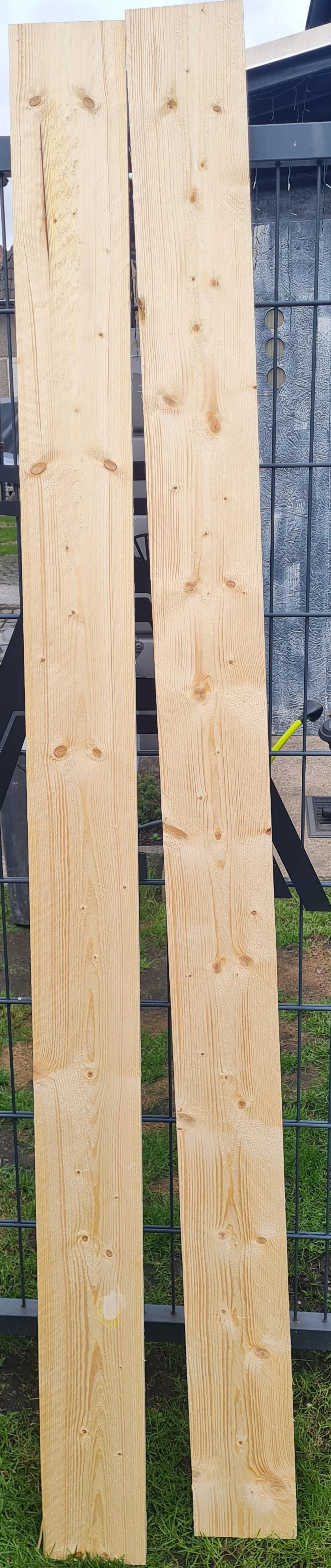 Zwei lange Holzbretter mit deutlicher Maserung.