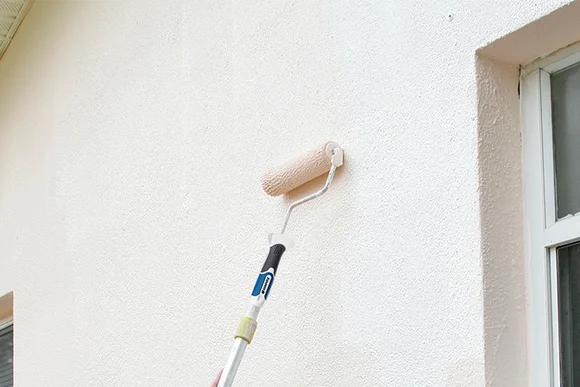 Hauswand wird mit Farbe gestrichen