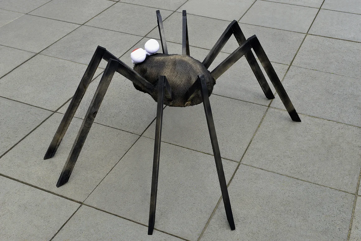 Spinne aus Holz auf Gehweg