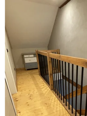 Hölzernes Treppengeländer mit schwarzen Metallstäben