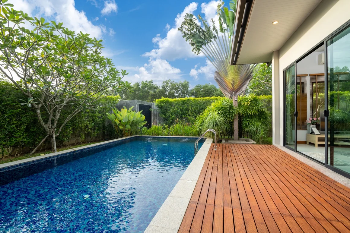 Pool mit Holzterrasse und Garten