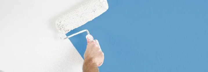 Person streicht Wand weiß