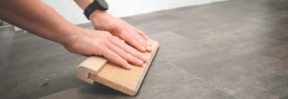Person verlegt PVC-Boden mit Andrückroller