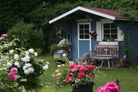 Blaues Gartenhaus im Garten mit Blumen