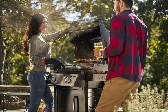 Zwei Personen beim Grillen im Garten
