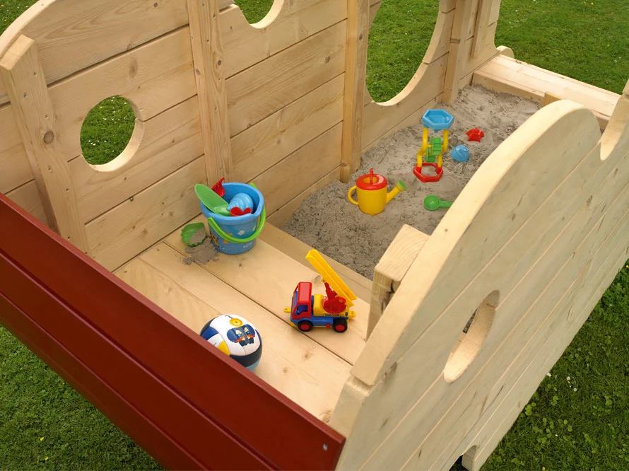Hölzernes Spielschiff mit Sandkasten gefüllt