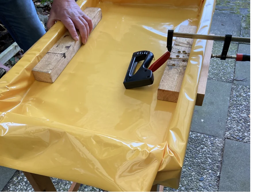 Handtacker befestigt Plane an Holzrahmen