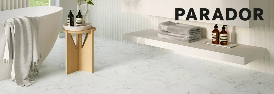 Parador Logo. Im Hintergrund: Helles Badezimmer mit Marmorfliesen
