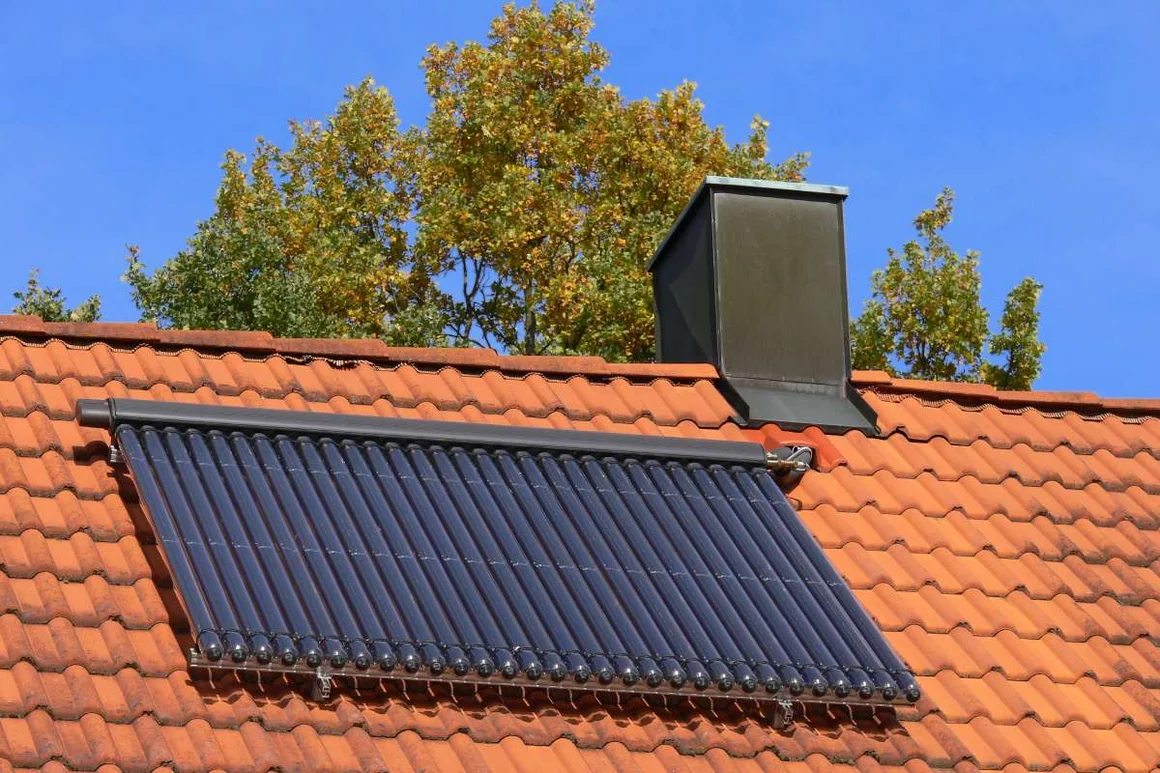 Solarthermieanlage auf einem Ziegeldach mit Schornstein.